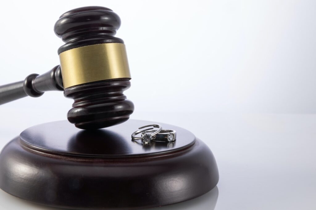 Closeup shot of the judge's gavel with wedding rings - concept of divorce