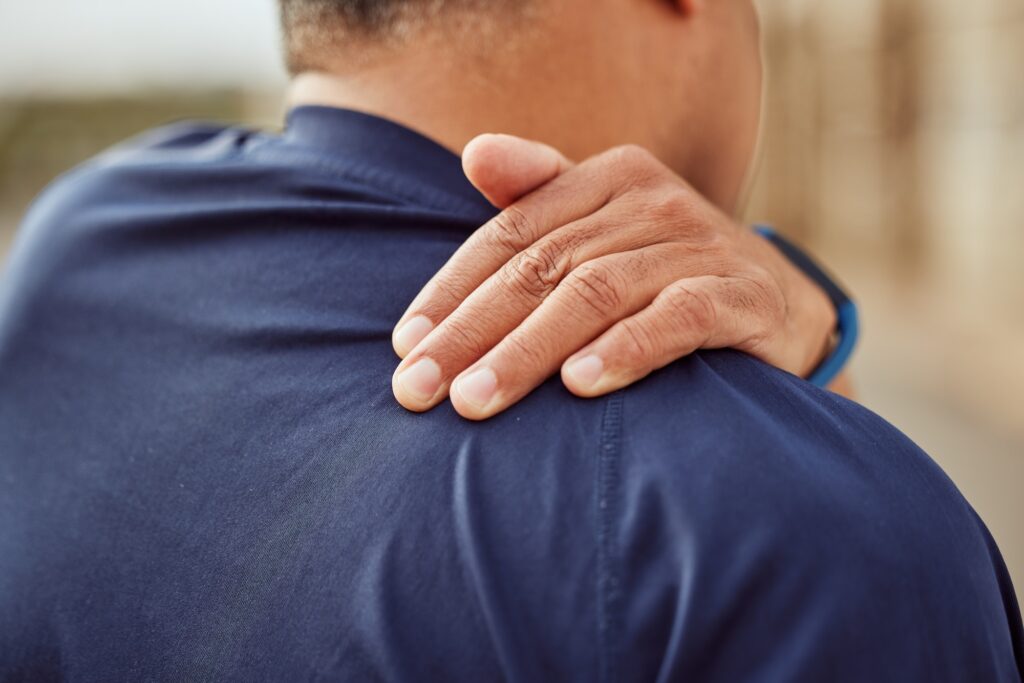 Fitness, back pain and man with hand on shoulder muscle for support, massage and relief during exer